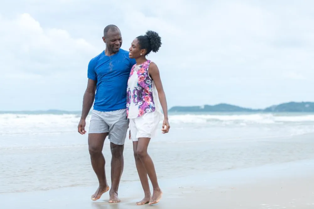 Happy Couple Enjoying A Playful Walk On The Beach