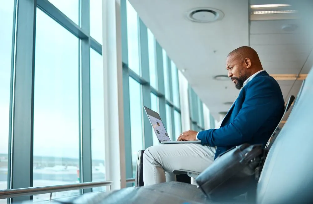 Travel Laptop And Website With Black Man In Airport