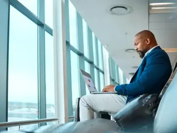 Traveler using a laptop while waiting at the airport