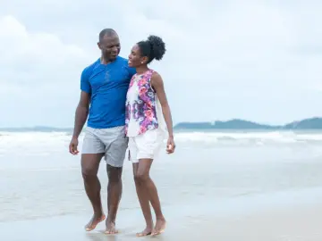 Couple enjoying a playful walk along the beach